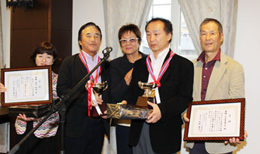 優勝した石内利光さんとガイドの齋藤芳子さん（左側・レギュラー）、千木良孝之さんとガイドの武藤規雄さん（右側・チャレンジ）、中央は岡田美智子プロ2